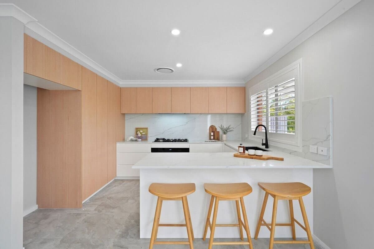 Designer kitchen with stone breakfast bar and timber cabinetry