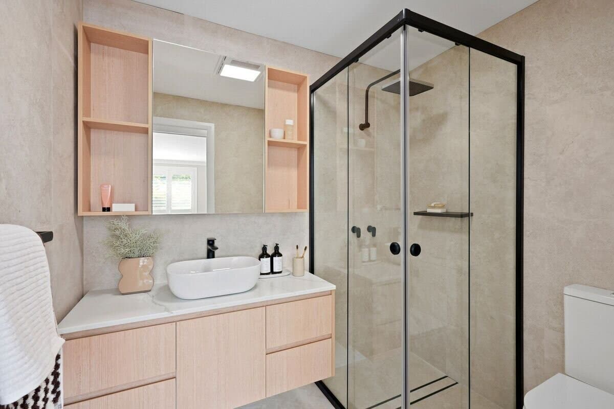 Ensuite bathroom with timber vanity, vessel sink and black-framed shower